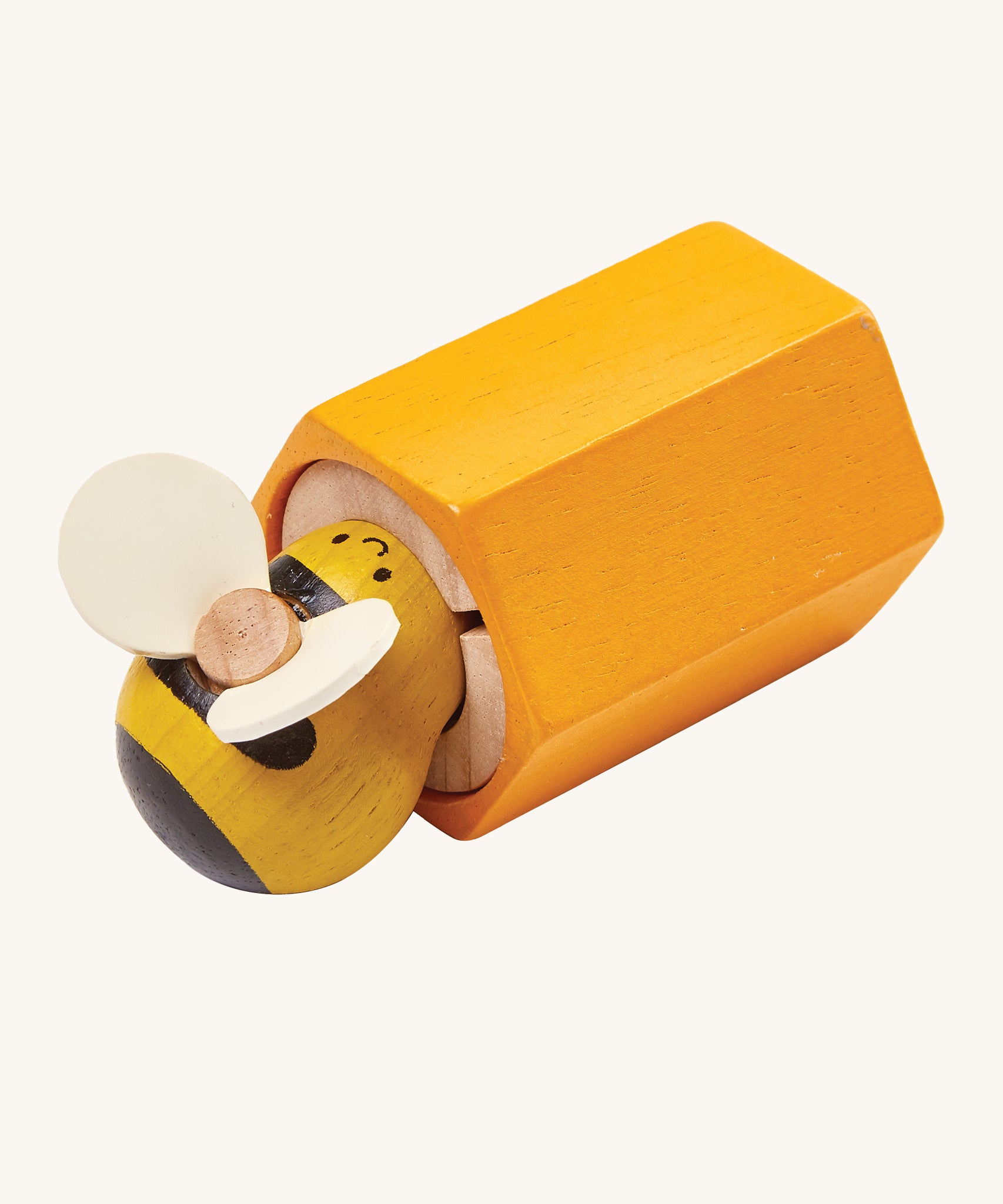 PlanToys Buzz Bee is a wooden grip and pull toy which zooms back into the bee hive once pulled. The hive is yellow, and the bee is yellow and black with cream wings. The image is on a cream background