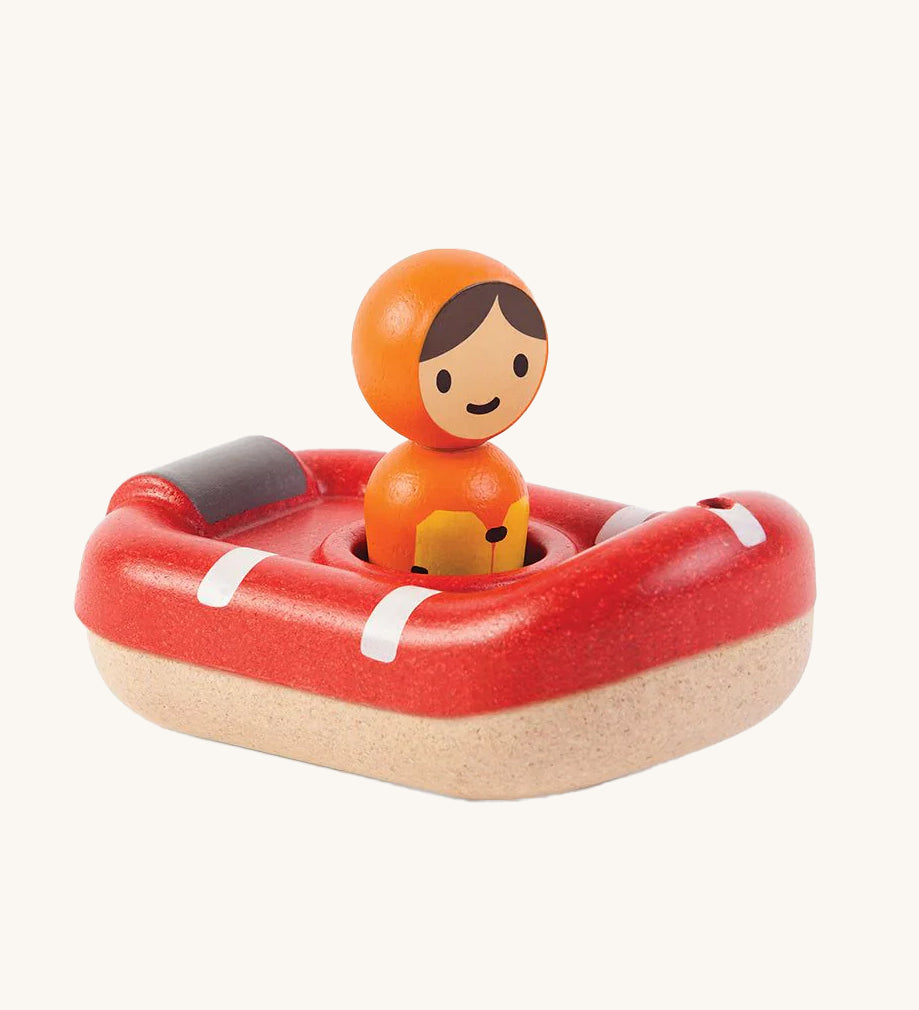 PlanToys Coast Guard Boat Bath Toy and Coastguard figure sat inside the boat, on a cream background