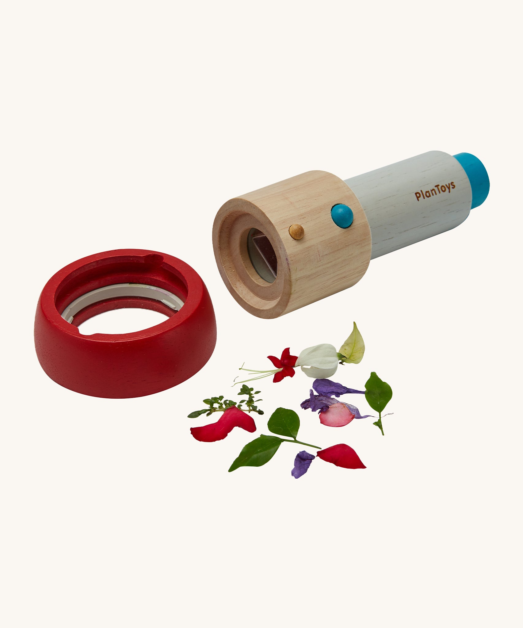 The PlanToys Kaleidoscope, with its red lens detached and flowers to the side, to show where to put the small objects that are to be looked at. The image is on a cream background