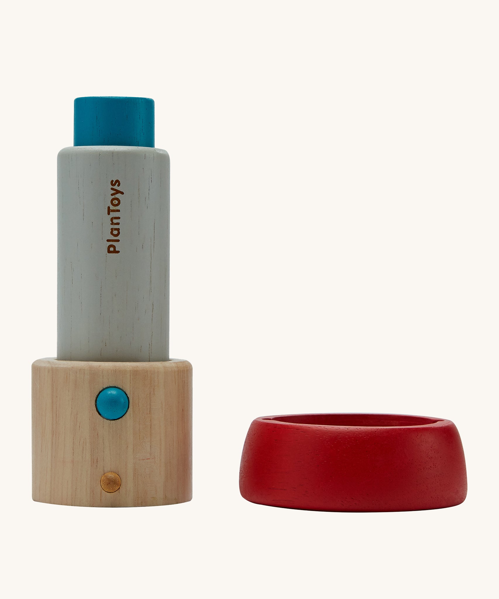 The PlanToys Kaleidoscope, made from PlanWood is in two parts in this image. The part on the left is the main body of the kaleidoscope which is blue and natural wood in colour, and the part on the right is the red lens