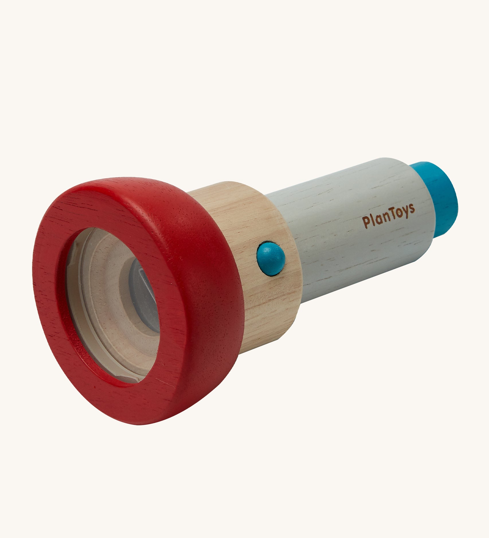 The PlanToys Kaleidoscope, is a plastic free, ethical alternative made from PlanWood which is a sustainable rubber wood. The kaleidoscope has a removable red lens cover to allow children to add small objects to look at. The image is on a cream background