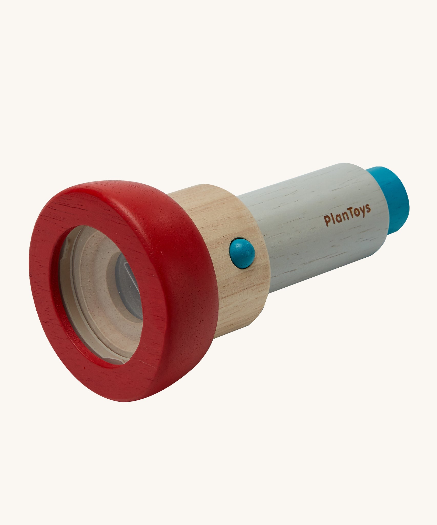 The PlanToys Kaleidoscope, is a plastic free, ethical alternative made from PlanWood which is a sustainable rubber wood. The kaleidoscope has a removable red lens cover to allow children to add small objects to look at. The image is on a cream background