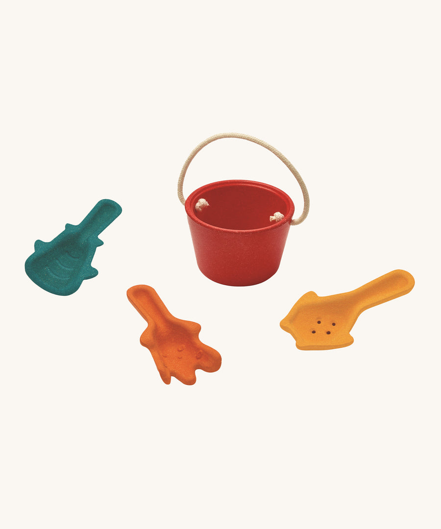 The PlanToys Sand Play Set Educational Toy includes a red bucket, and three textured scoops for sensory play