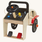 The back of the PlanToys Motor Mechanic showing the push-able black and red pedal at the bottom, the steering wheel, gear stick, key ignition and dials, on a cream background