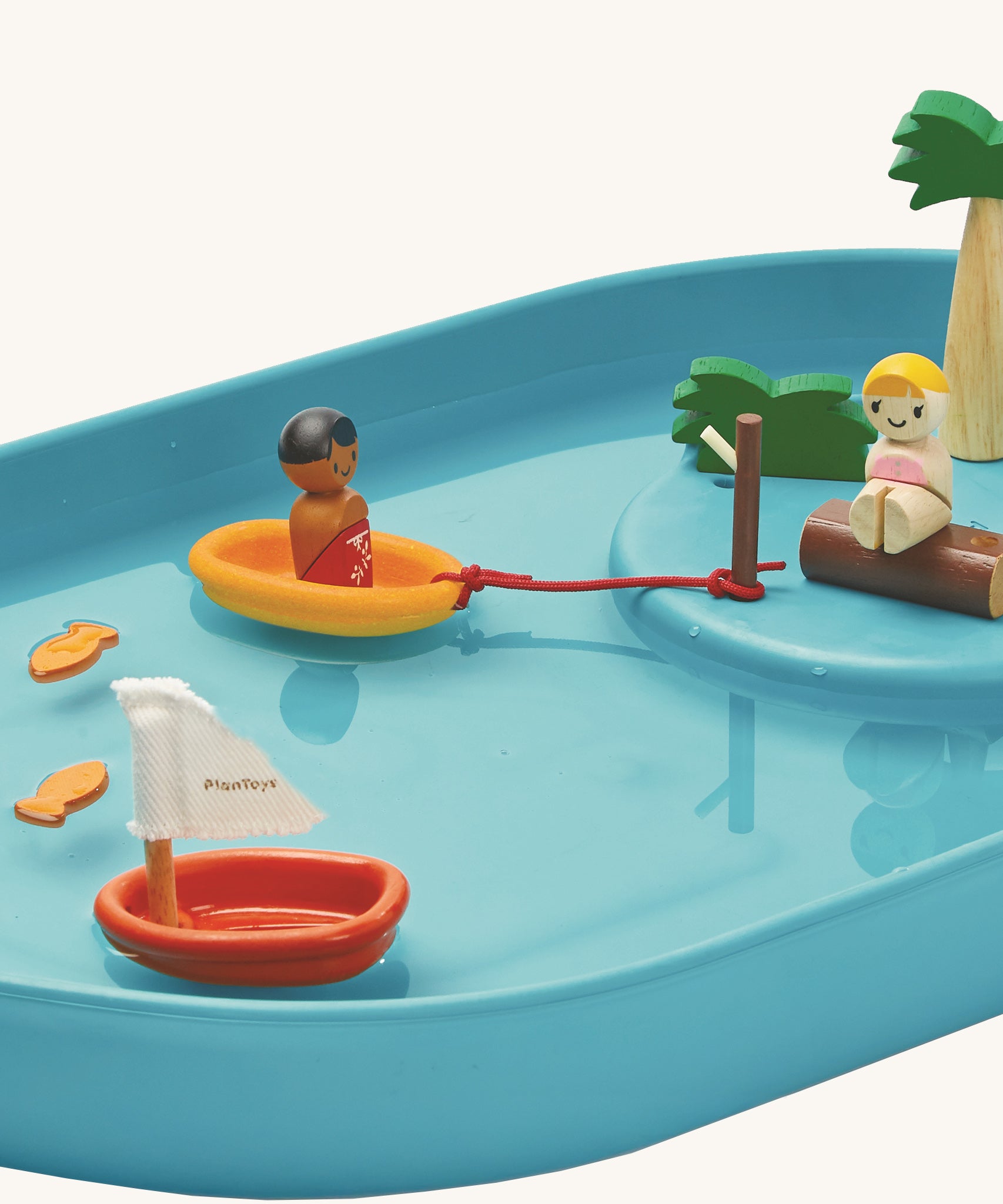 A closer look at the figures in the PlanToys Water Play Set relaxing on the raised island and in a yellow boat