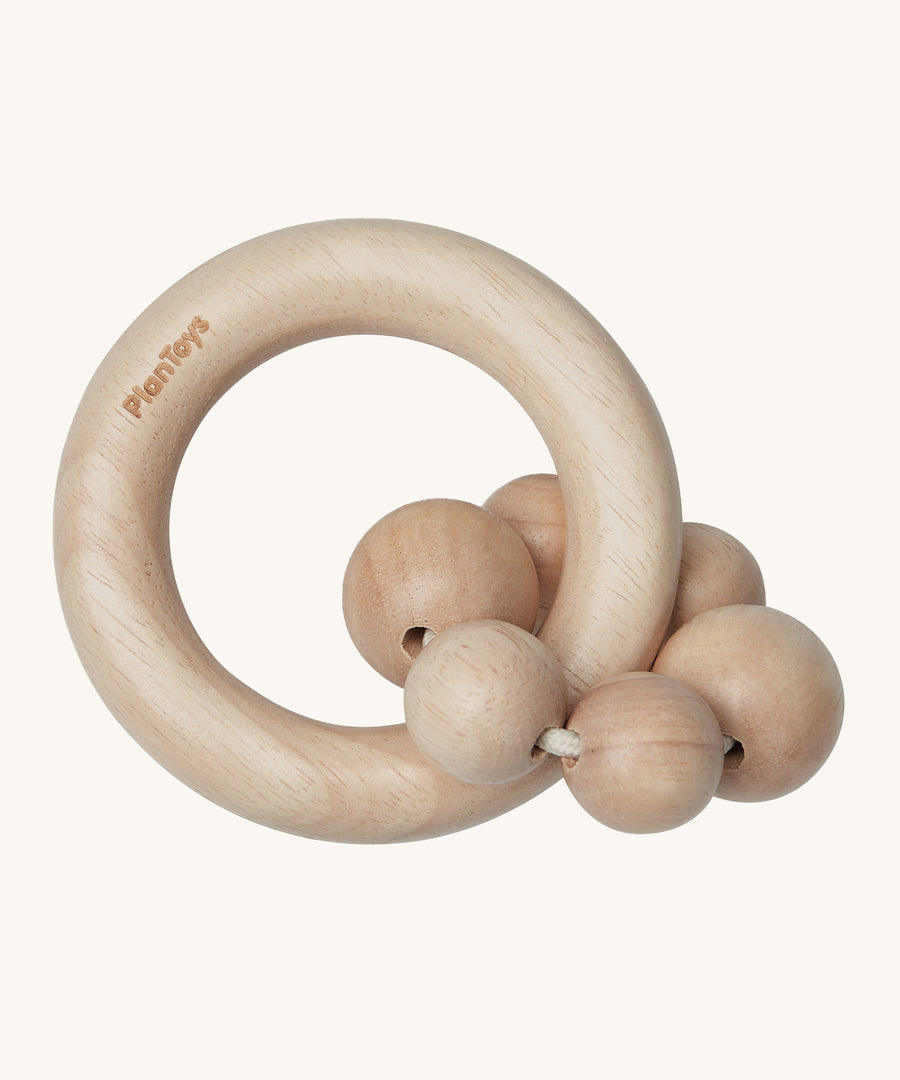 PlanToys Natural Wooden Beads Rattle is a beautifully crafted, wooden baby rattle that is perfect for teething and sore gums. The rattle comes with a wooden ring, and attached to the ring natural wood beads. The image is on a cream background