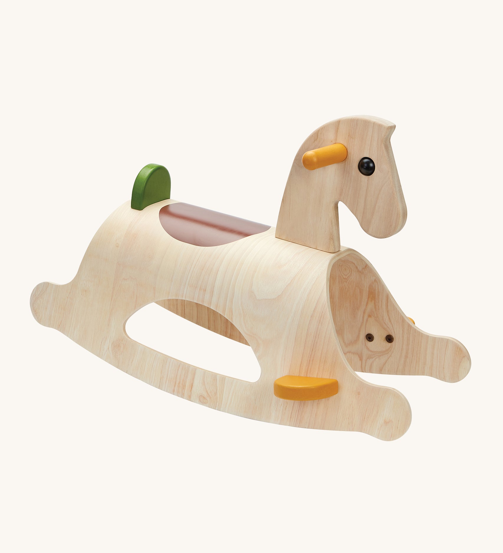 PlanToys Palomino Rocking Horse - Modern Rustic is a beautiful first rocking horse for any child. This rocking horse is in natural wood showing the wood-grain, with yellow handles and foot plates, a brown seat patch on the back of the horse, and a green back rest. The image is on a cream background