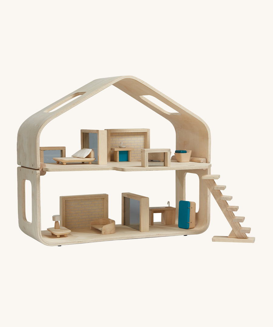 Plan Toys Contemporary Dolls House on a cream background. The image shows the inside of the dolls house with PlanToys doll house furniture