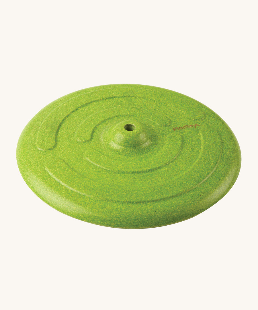 The Green PlanToys Saucer Disc Swing without the rope, showing the smooth Rubberwood texture and design of the swing seat. On a cream background