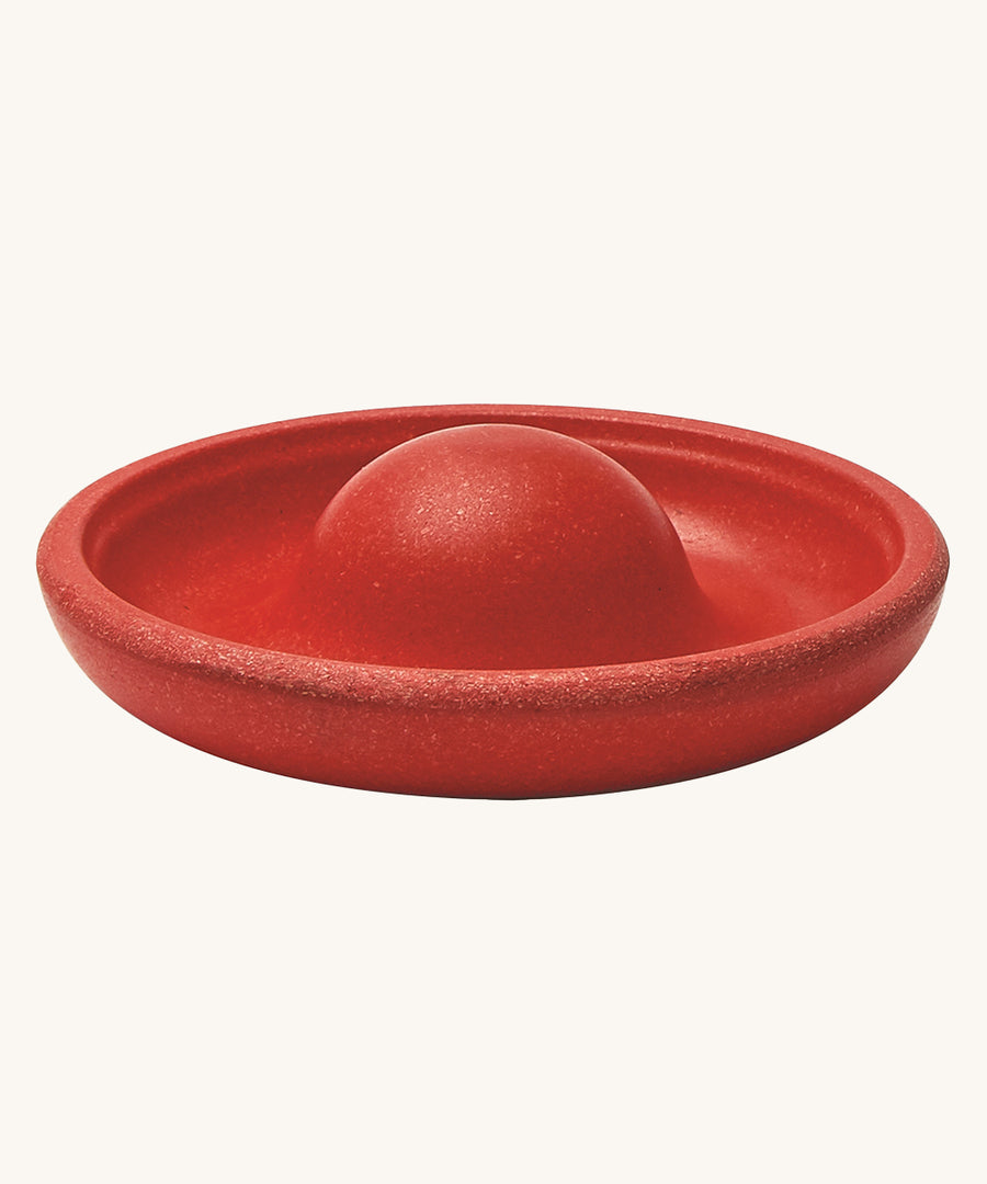 The red disk block from the PlanToys Creative Sand Play set, with a dome in the middle to allow for water to collect and run through