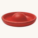 The red disk block from the PlanToys Creative Sand Play set, with a dome in the middle to allow for water to collect and run through