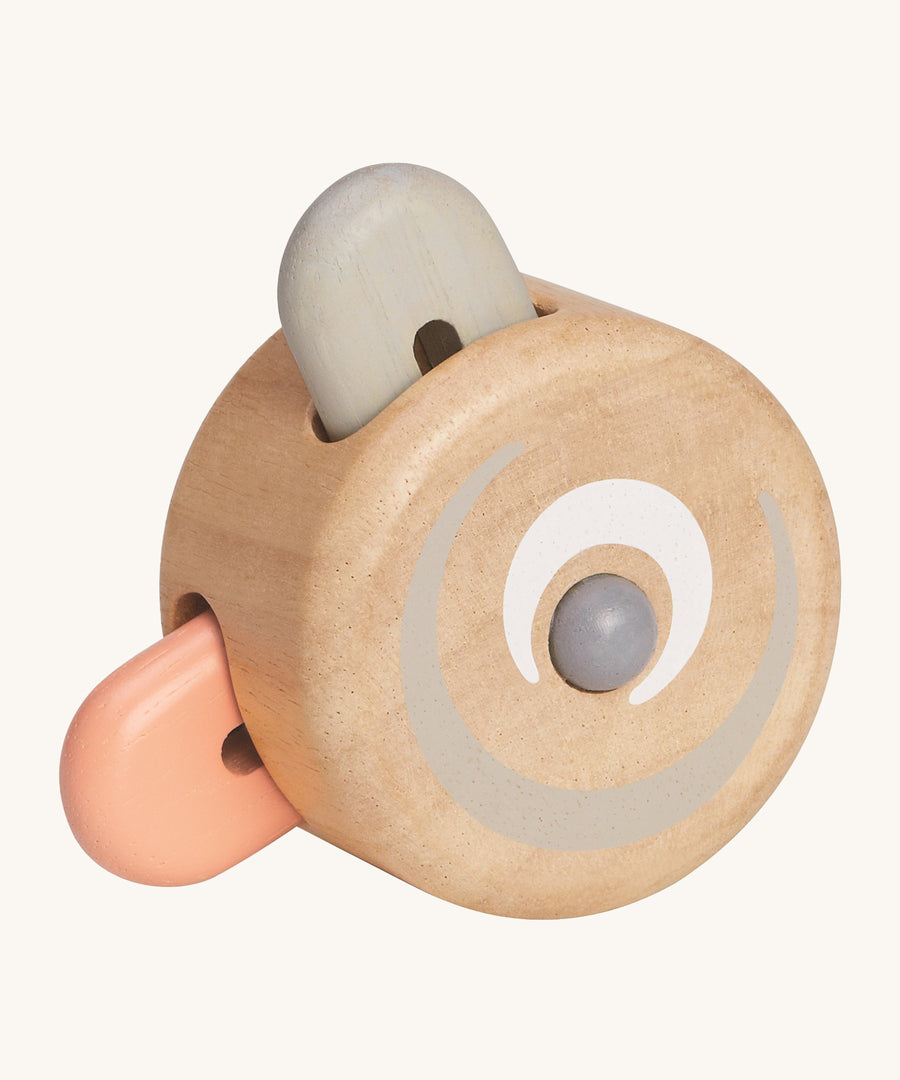 The PlanToys Wooden Pastel Peek-A-Boo Roller is a perfect rolling and push toy for babies and little ones. The round roller has two wooden teddy bear ear shaped pieces, one in peach and one in grey, that pop inside the natural wooden roller when rolled along the ground. The image is on a cream background