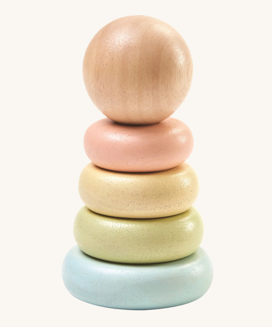 PlanToys Pastel First Stacking Ring, is a perfect first stacking ring for babies and little ones. The stacking rings are on a pastel blue base, and the ring colours are pastel green, pastel yellow, and pastel peach. On top is a natural wooden ball which can be used as a rolling toy. The image is on a cream background