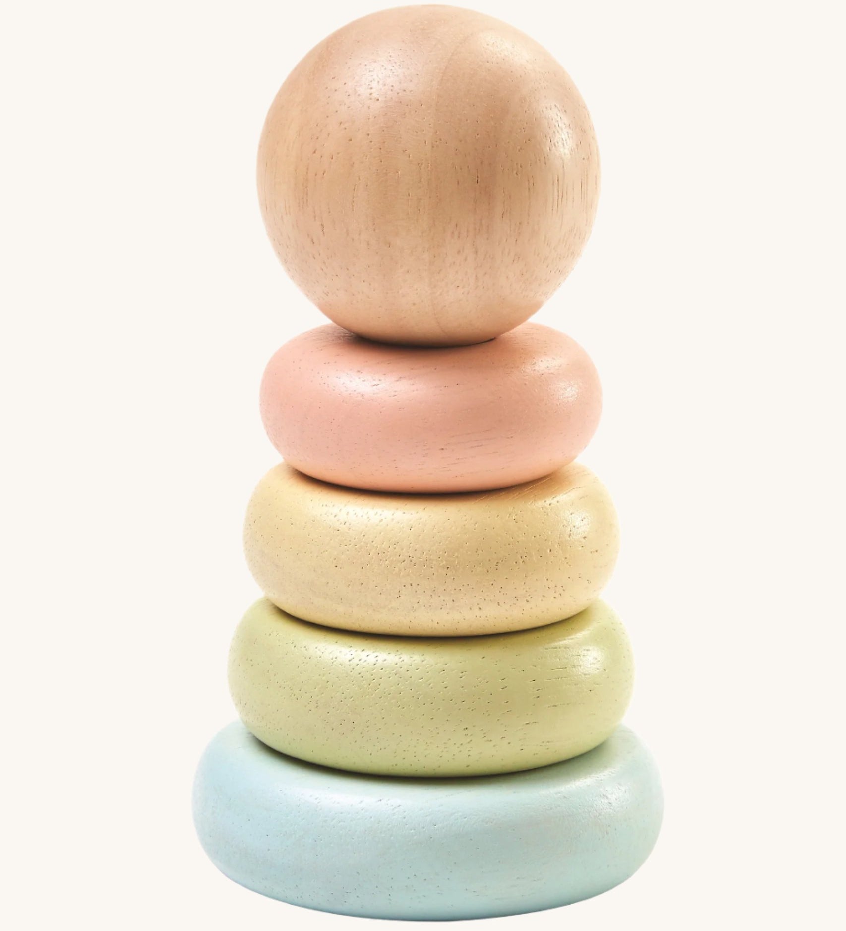 PlanToys Pastel First Stacking Ring, is a perfect first stacking ring for babies and little ones. The stacking rings are on a pastel blue base, and the ring colours are pastel green, pastel yellow, and pastel peach. On top is a natural wooden ball which can be used as a rolling toy. The image is on a cream background