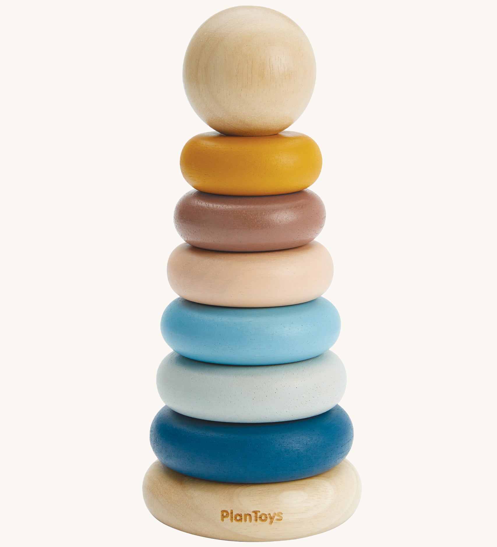 The PlanToys Stacking Rings are a fun and educational toy for children. The set comes with 6 rings in shades of blue, peach and yellow, and has a removable ball on the top that can be rolled on the ground or put inside the ring holes. The image is on a cream backround.