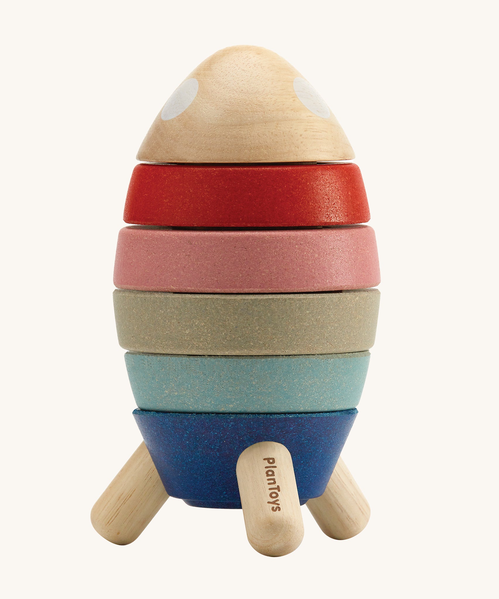 Plan Toys Wooden Stacking Rocket Orchard, has four coloured discs that make up the rocket, each with a cut out for a shape to go into, and a cute little astronaut who hides inside. The image is on a cream background