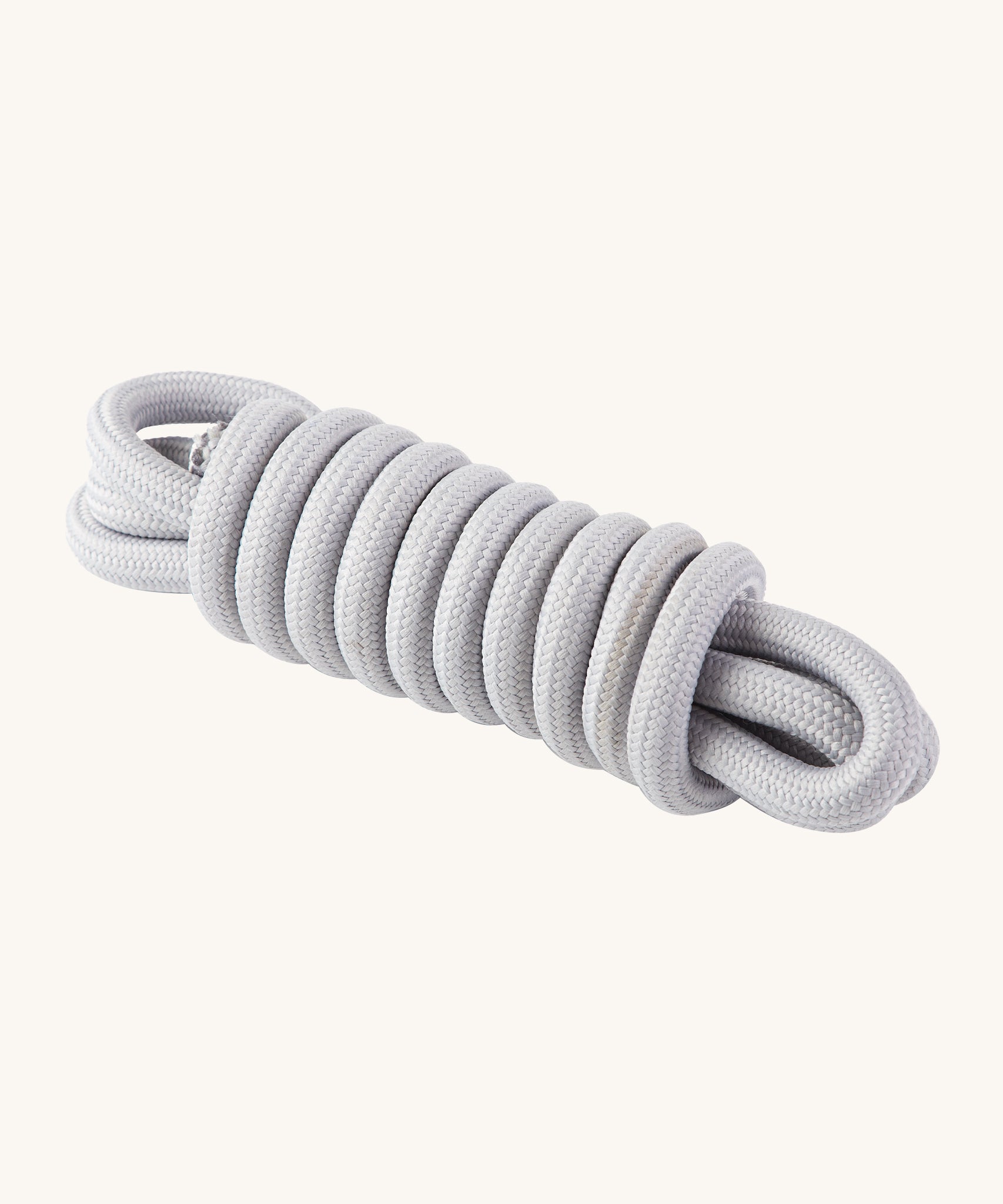 The white rope which attaches to the PlanToys Saucer Disc Swing, in white. On a cream background