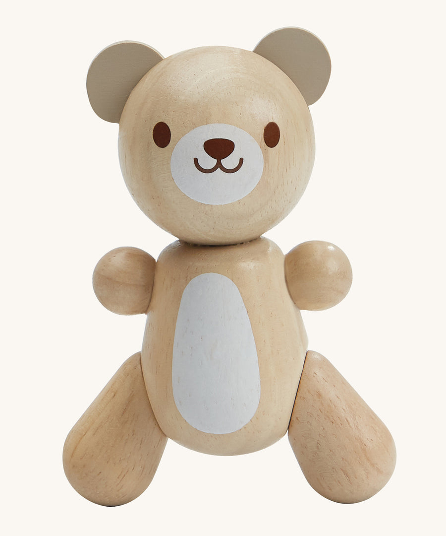 PlanToys Little Bear is an adorable wooden teady bear toy, which is perfect for babies and little ones. The smooth design of the teddy means little ones can get a good grip on the teddy. The teddy has a white patch on its belly and a smiling face. The image is on a cream background.