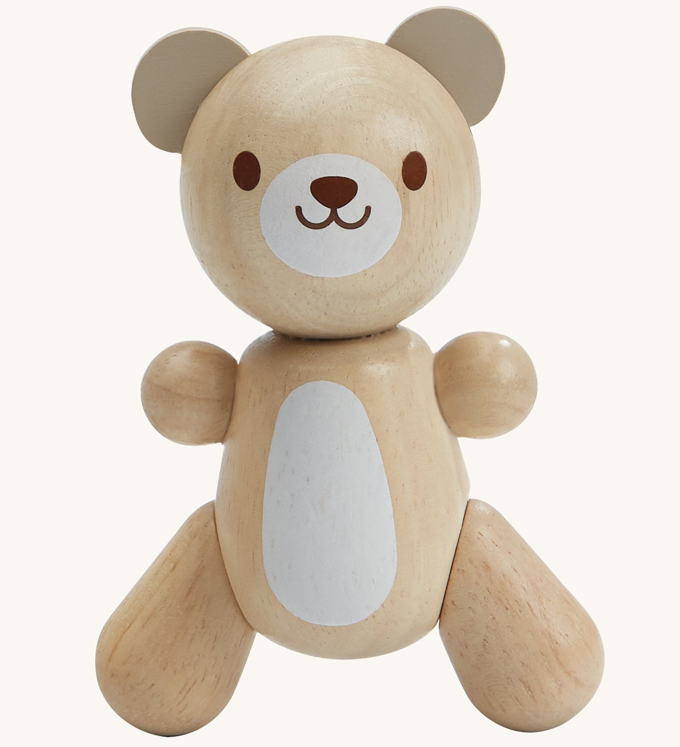 PlanToys Little Bear is an adorable wooden teady bear toy, which is perfect for babies and little ones. The smooth design of the teddy means little ones can get a good grip on the teddy. The teddy has a white patch on its belly and a smiling face. The image is on a cream background.