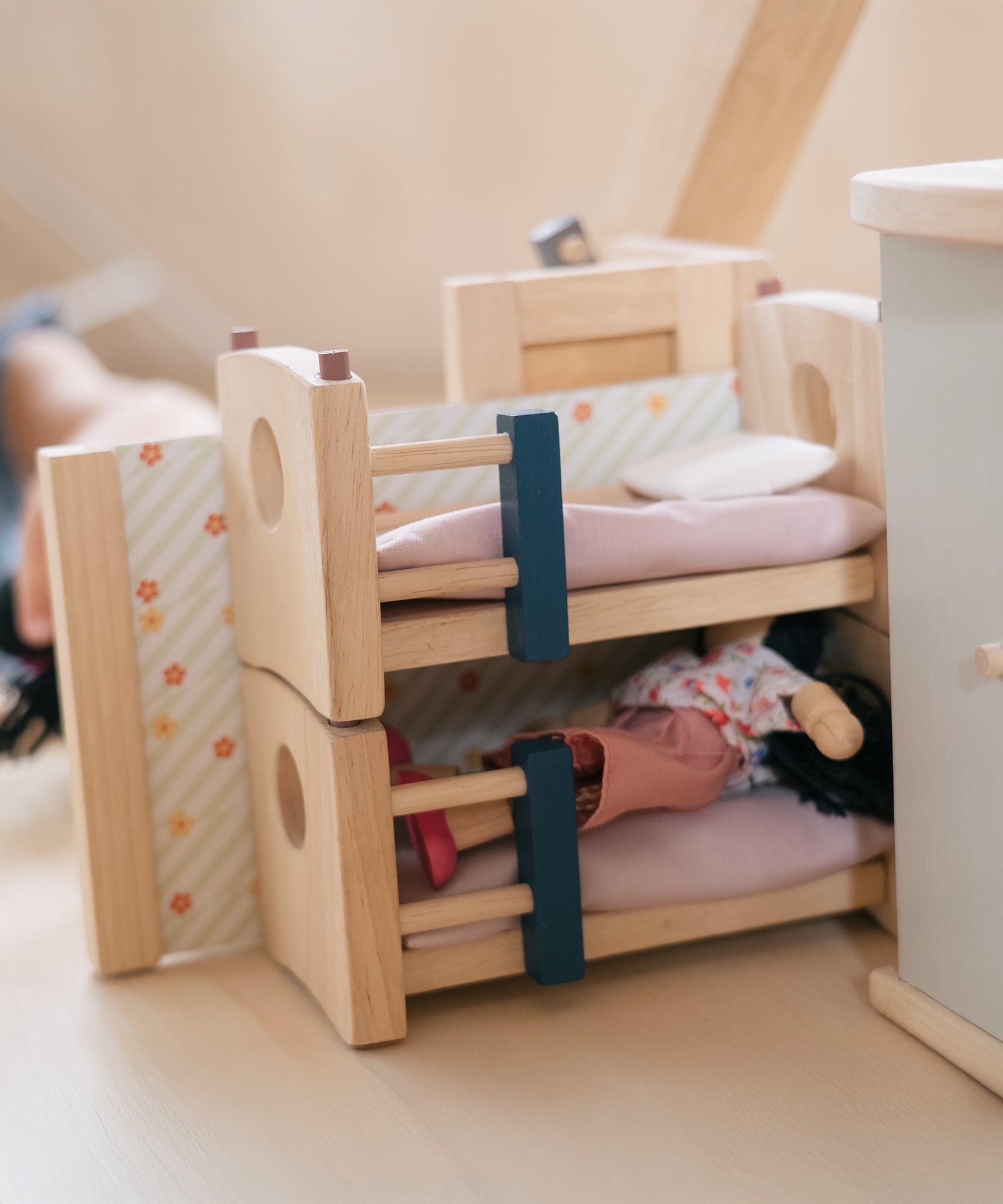 A closer look at a doll sleeping in the bottom bunk bed