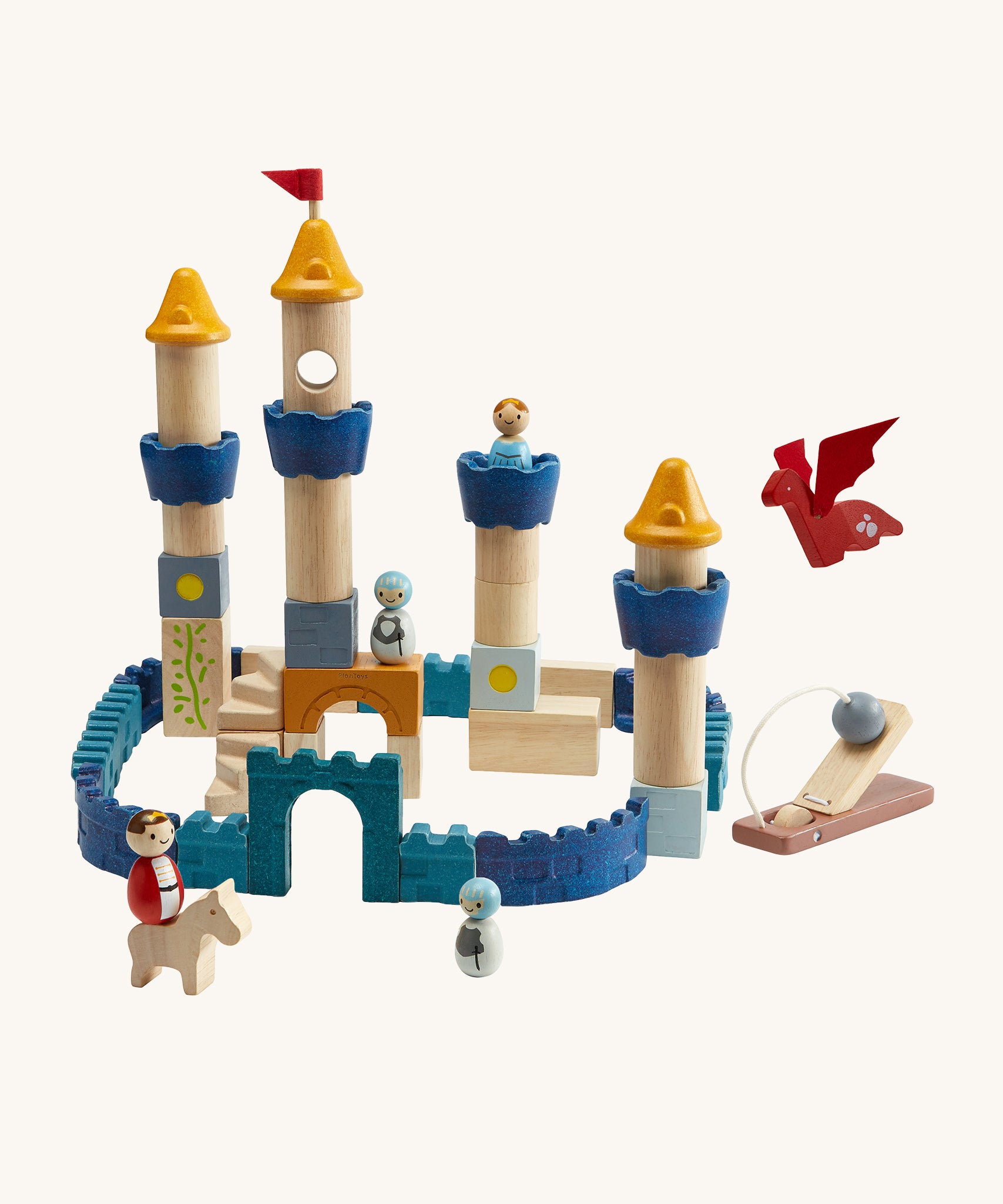 The PlanToys Castle Building Blocks in Orchard colours, made into a colourful castle display. The set comes with castle wall blocks in shades of blue, blocks to make castle towers and turrets, little people figures, a horse, a dragon and a catapult to defend the castle. The image is on a cream background