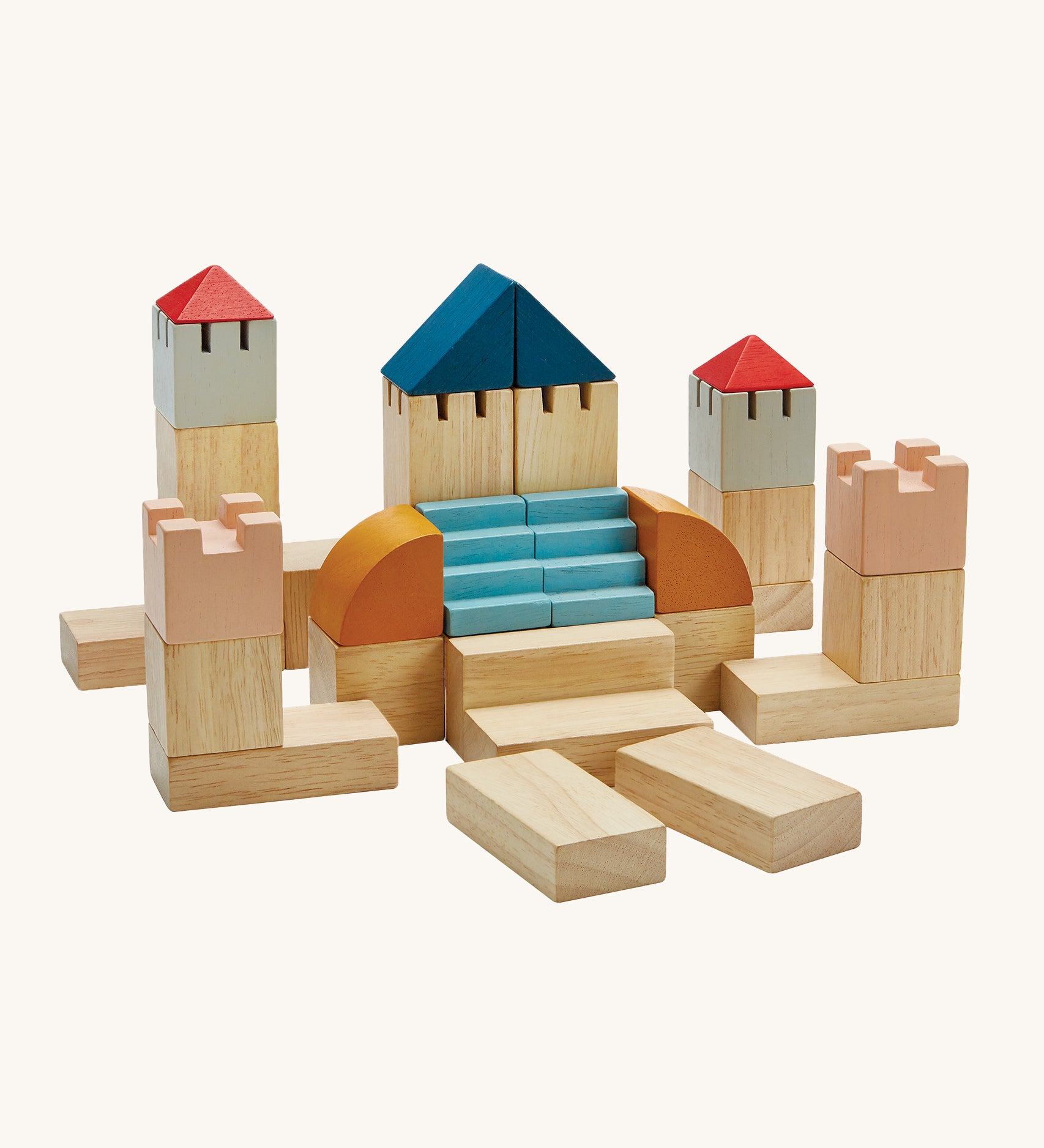 PlanToys Creative Blocks in the colourwave Orchard, are a set of building blocks in various shapes and colours which include natural coloured blocks, coral pink, blue, red, grey and mustard. The image is on a cream background