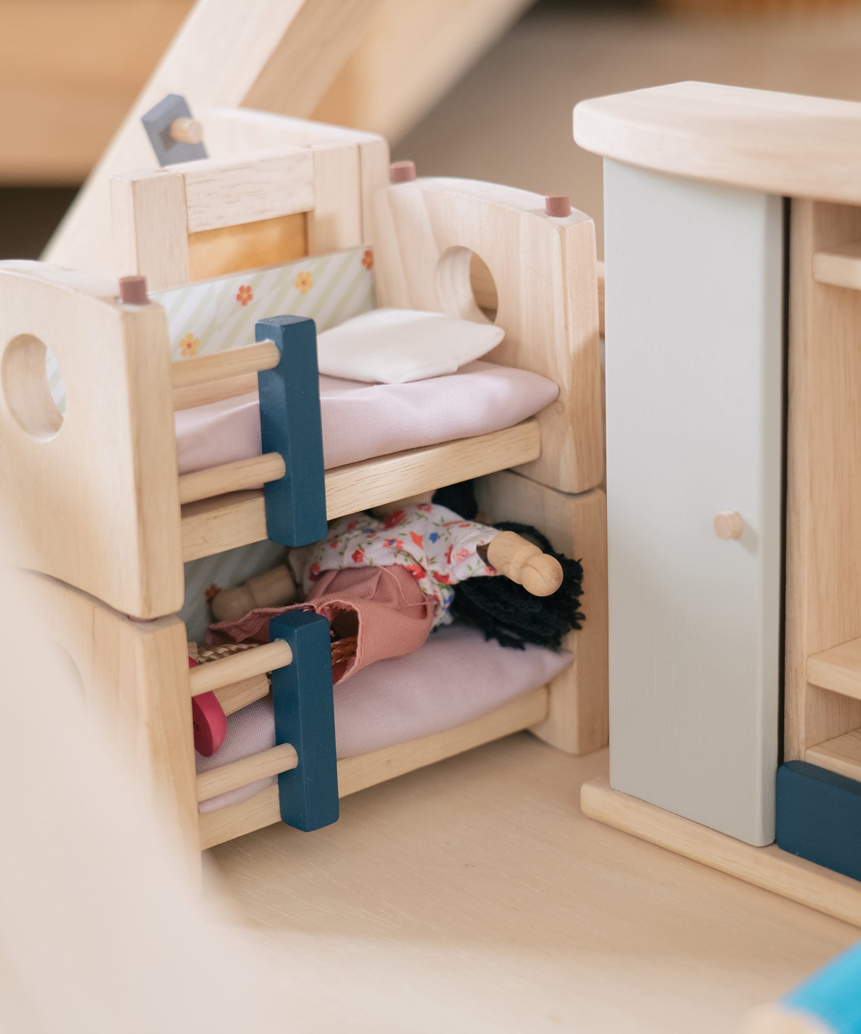 A closer look at a doll sleeping in the bottom bunk bed