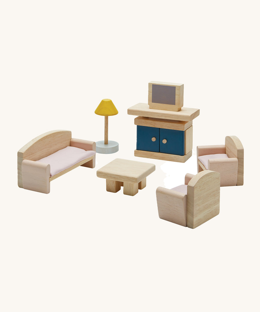 Plan Toys Living Room Dolls House Furniture Set, featuring Wooden chairs, a sofa, a coffee table, a lamp and a TV with a TV unit. On a cream background