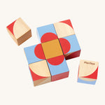 The PlanToys Geo Pattern Cubes are a fantastic STEM toy for children. The image shows 3 cubes each with a geometric petterns in the colours red, blue, orange, white and natural wood. The images shows 7 blocks together in the center with a block either side, on a cream background