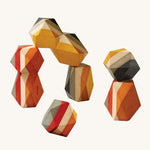 PlanToys Geo Stacking Rocks, are a colourful set of wood blocks with geometric rock shapes. The rocks are striped and are mustard, cream, red and grey in colour. The image is on a cream background