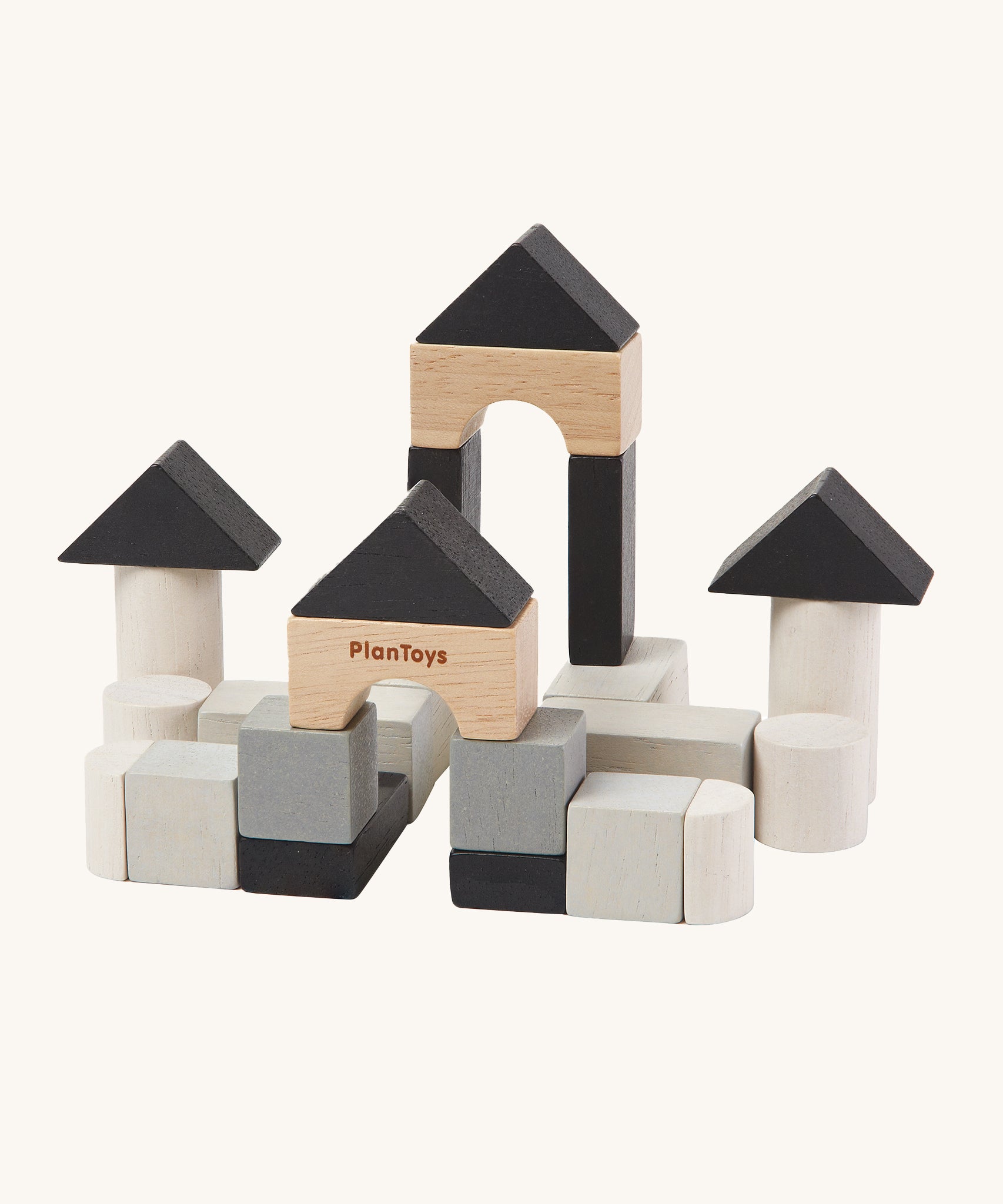 The PlanToys Mini Construction Set with various shaped blocks in shades of grey, black and natural colours on a cream background