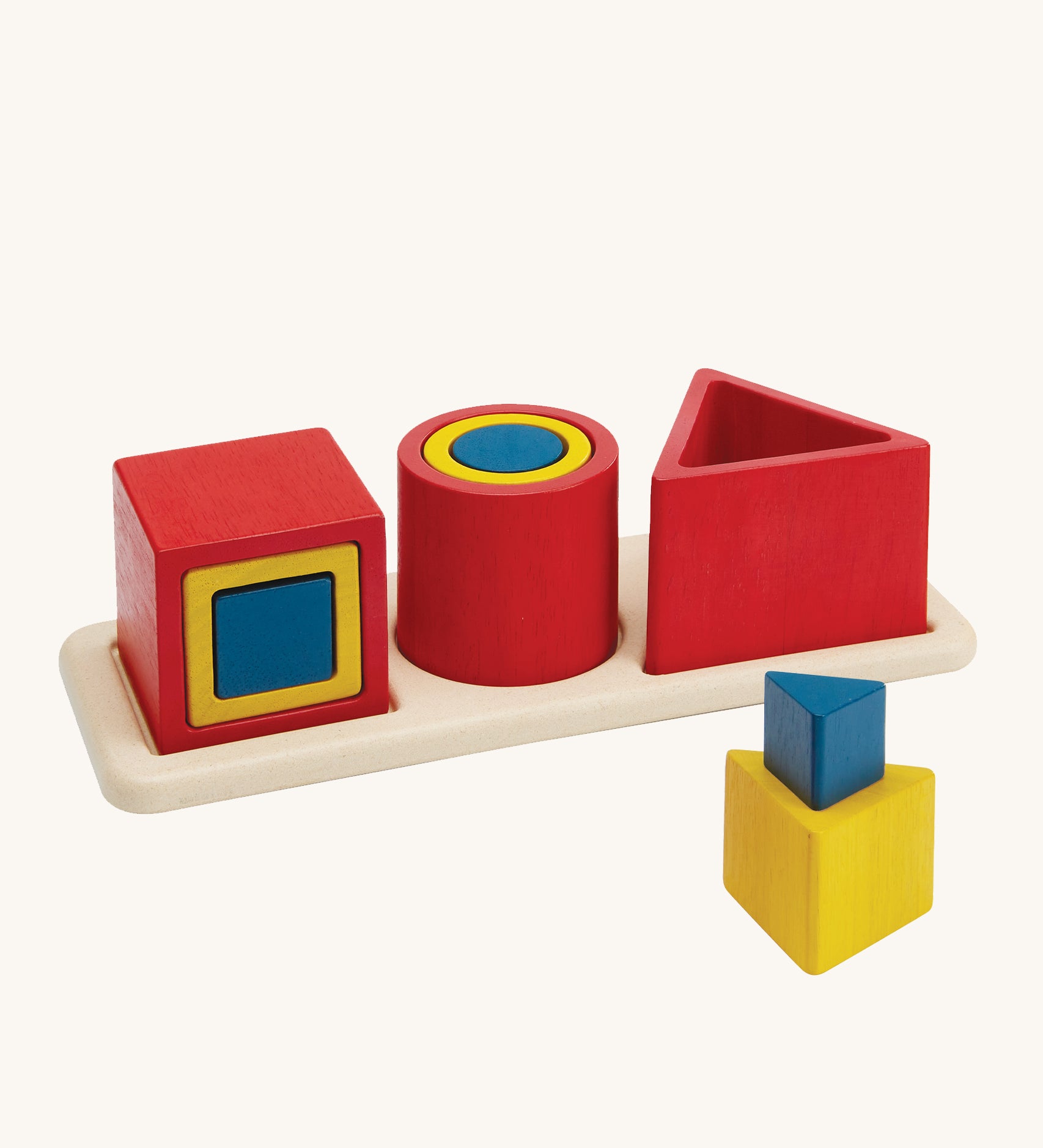 PlanToys Matching & Nesting Shapes Puzzle, is a fun wooden learning and educational toy for children. In the image are 3 square blocks inside each other, 3 circle blocks inside each other and 3 triangle block, with one on the wooden base and two in front stacked on each other. The colours of the blocks are red, yellow and blue, and are on a cream background 