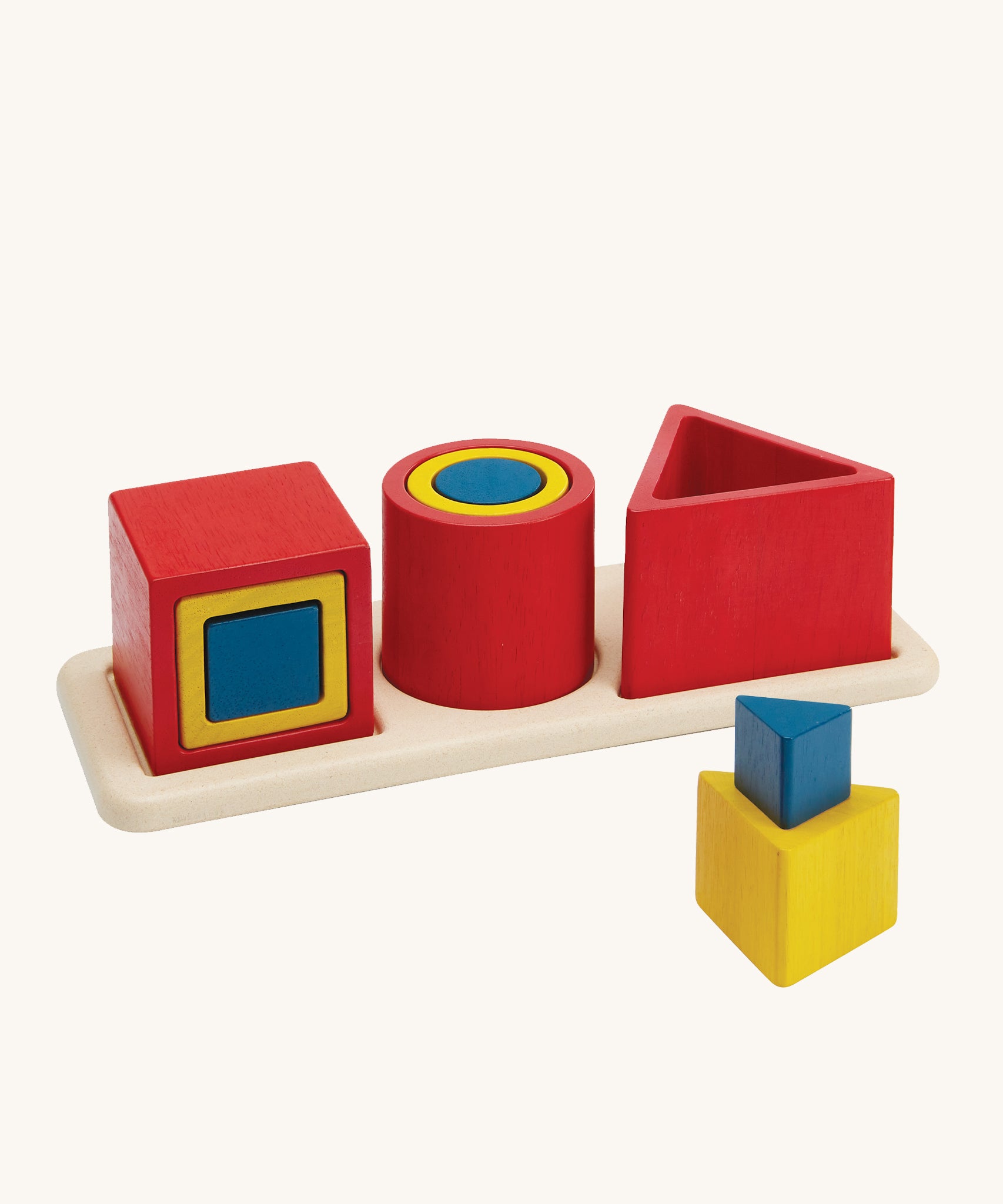 PlanToys Matching & Nesting Shapes Puzzle, is a fun wooden learning and educational toy for children. In the image are 3 square blocks inside each other, 3 circle blocks inside each other and 3 triangle block, with one on the wooden base and two in front stacked on each other. The colours of the blocks are red, yellow and blue, and are on a cream background 