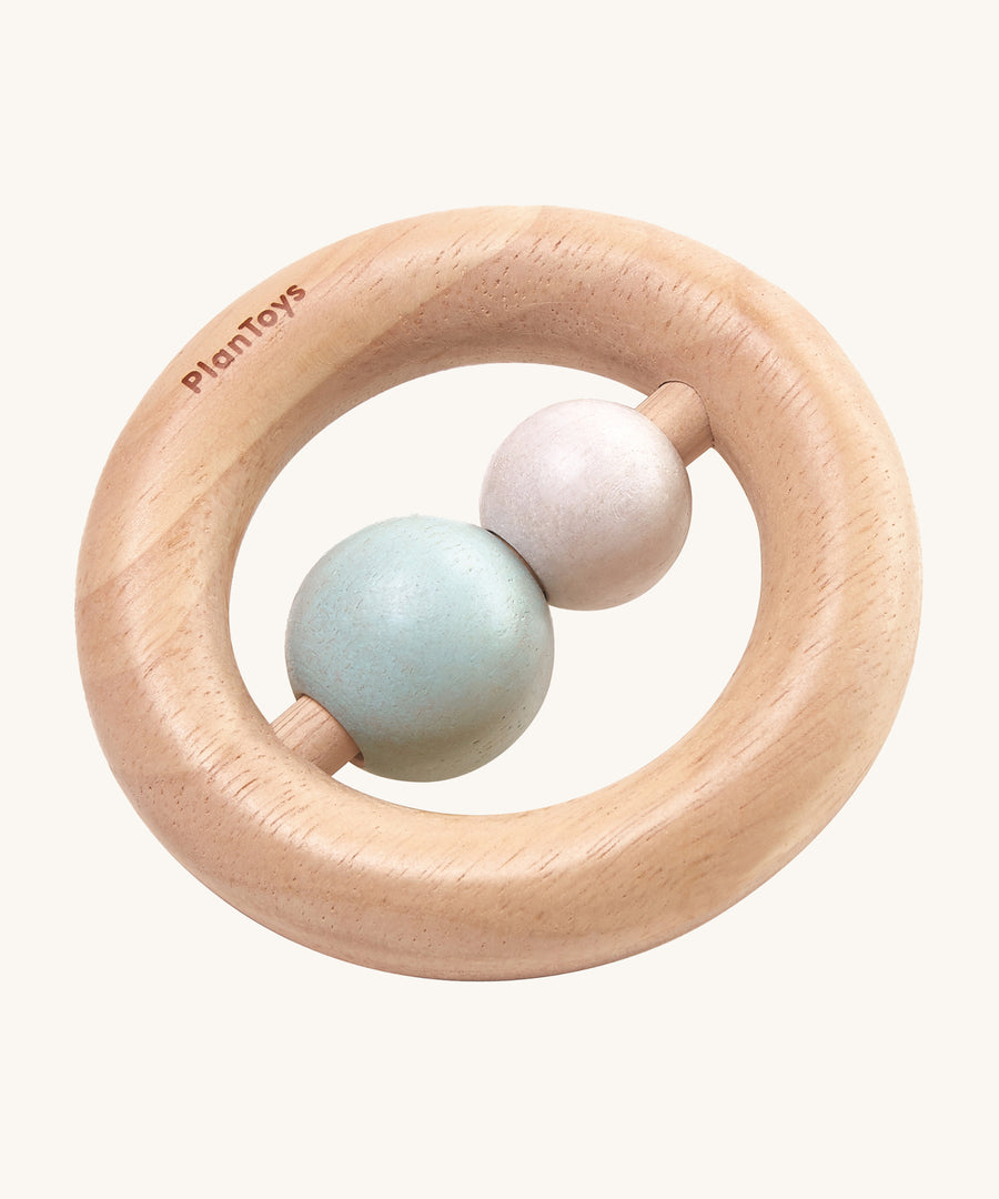 The PlanToys Pastel Ring Rattle is a natural wood ring rattle, with 2 pastel coloured beads in the centre. This ring shape baby rattle is easy for little fingers to grasp, and the 2 beads give a satisfying rattle when shaken. The image is on a cream background