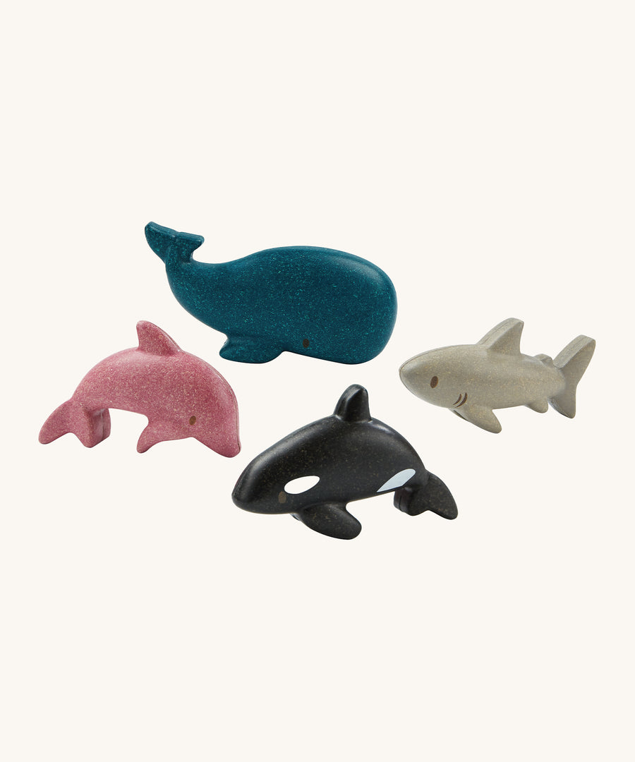 The PlanToys Sea Life Set comes with four adorable marine life figures which include a pink dolphin, a blue whale, a grey shark and a black and white orca. The image is on a cream background