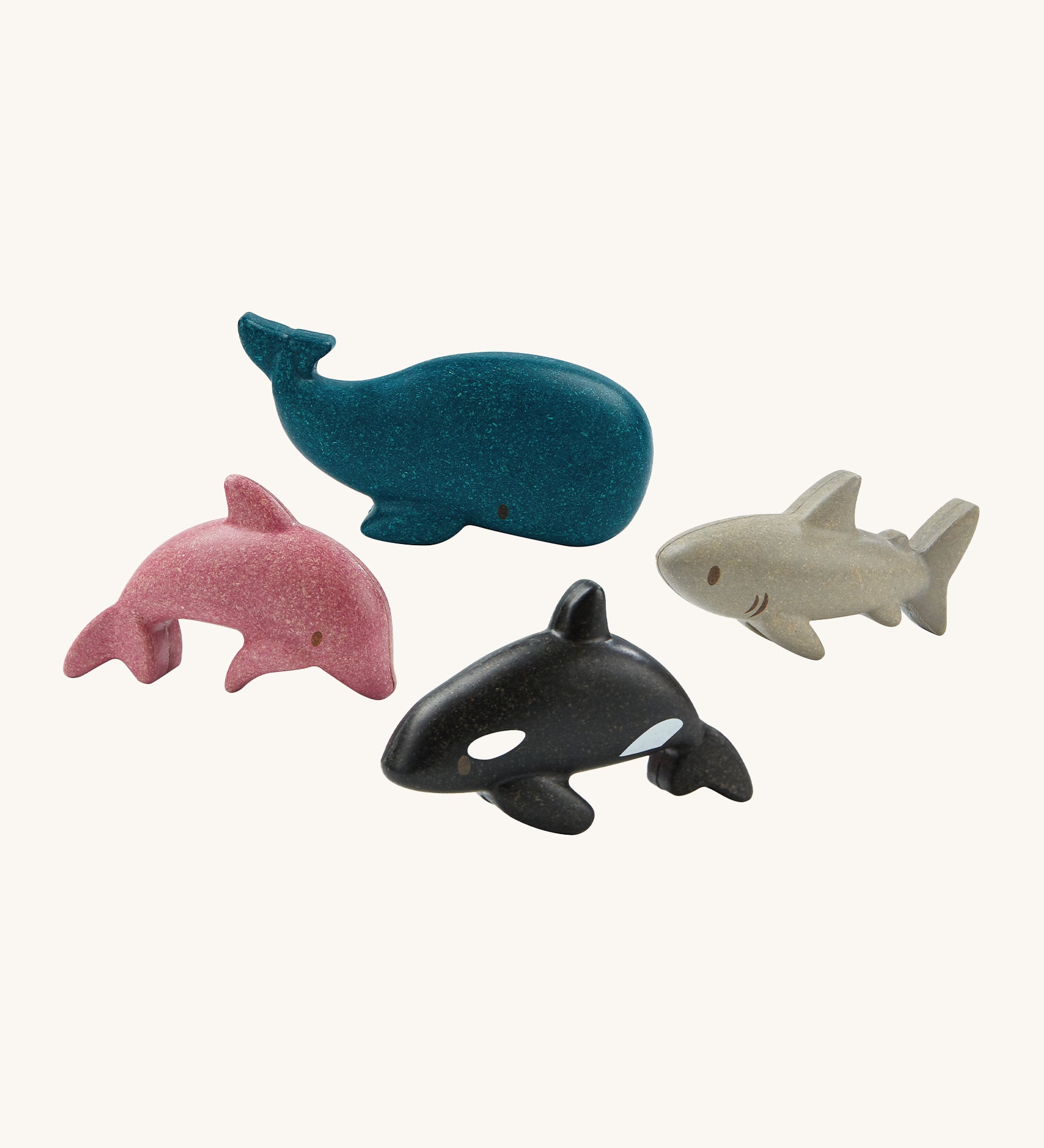 The PlanToys Sea Life Set comes with four adorable marine life figures which include a pink dolphin, a blue whale, a grey shark and a black and white orca. The image is on a cream background