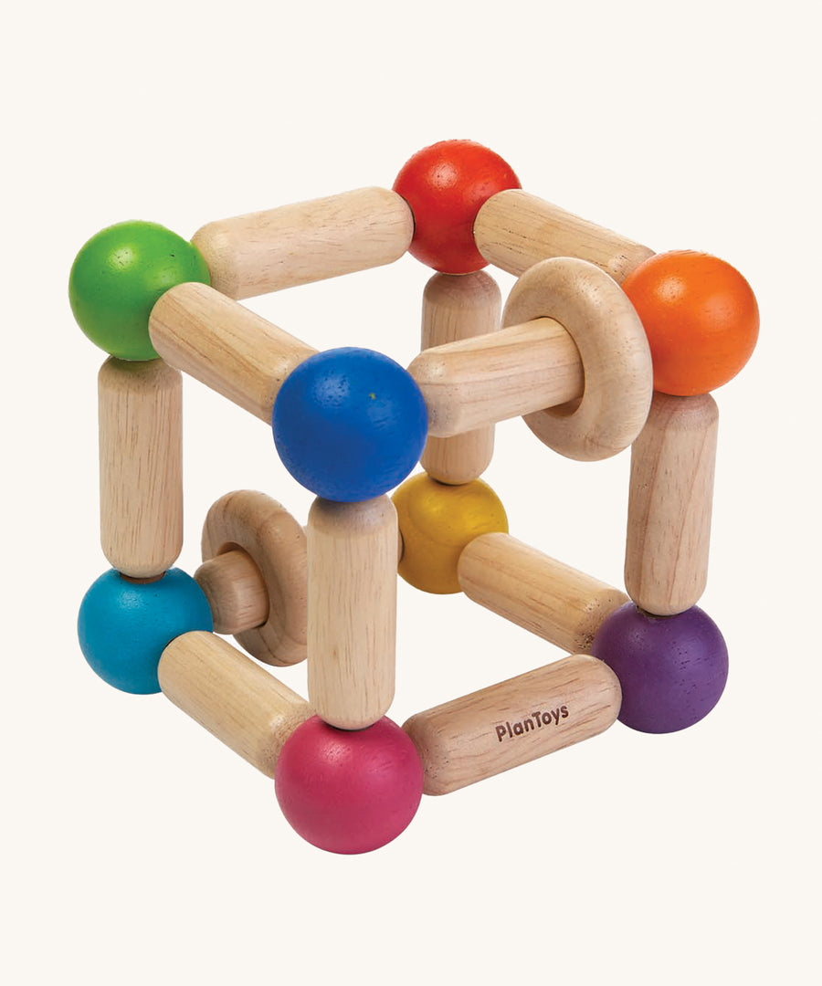 The PlanToys Wooden Square Clutching Toy, is a fun and interactive toy for babies and little ones. This sensory toy from PlanToys is made up of a flexible cube made up from wooden lengths and painted beads in rainbow colours, and two wooden rings that move on the lengths. The image is on a cream background