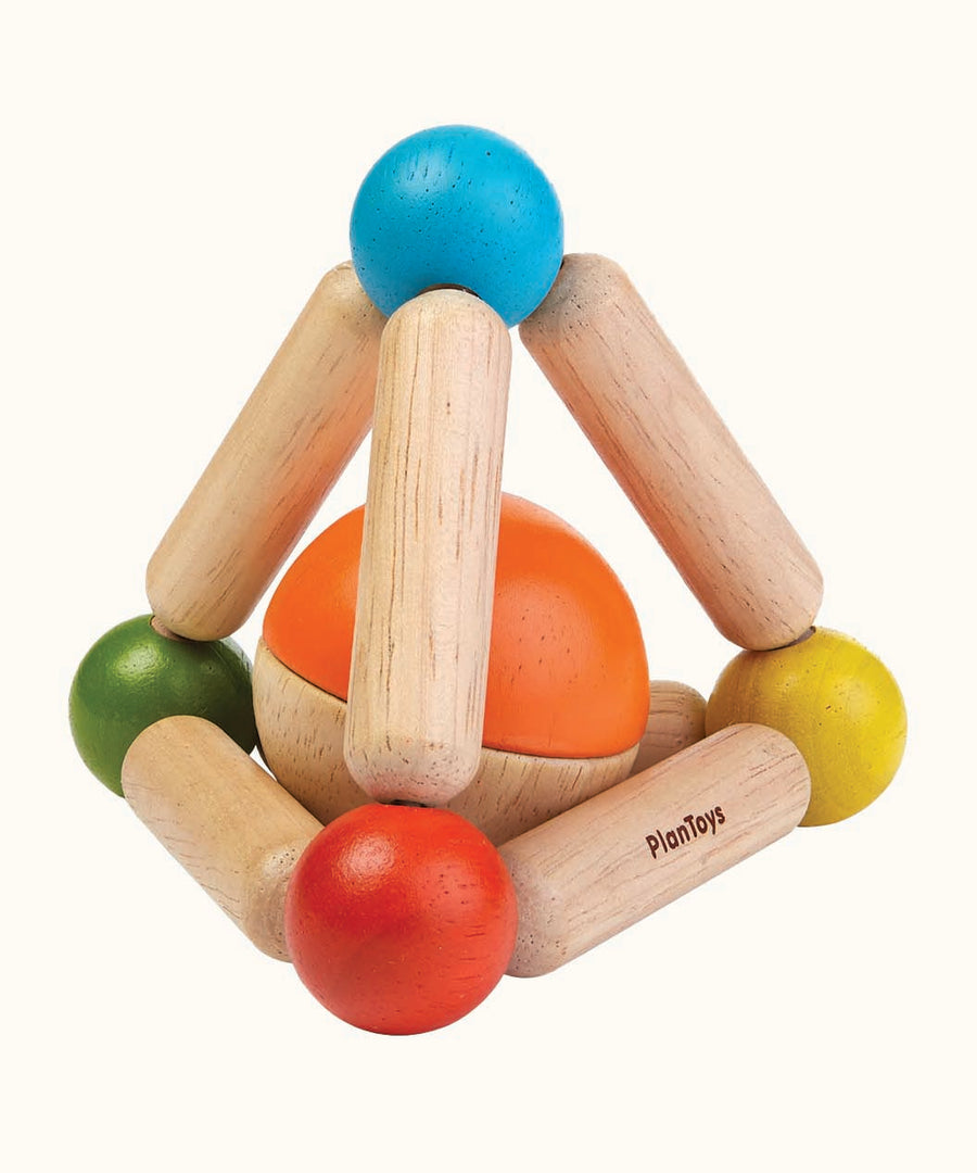 The PlanToys Wooden Triangle Clutching Toy, is a fun and interactive toy for babies and little ones. This sensory toy from PlanToys is made up of a flexible pyramid made up from wooden lengths and painted beads in the colour blue, red, green and yellow, with a chunky ball inside, which can be removed to be played with separately. The image is on a cream background