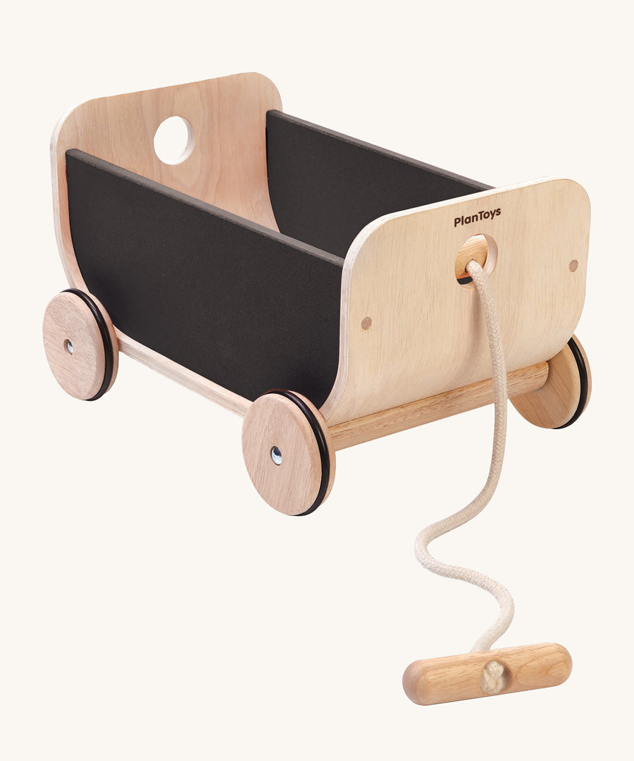 PlanToys Wooden Black Cart Toy, is a lovely push and pull toy with a curved front and back, and black sides. The wagon also come with a removable beige rope and handle, on a cream background