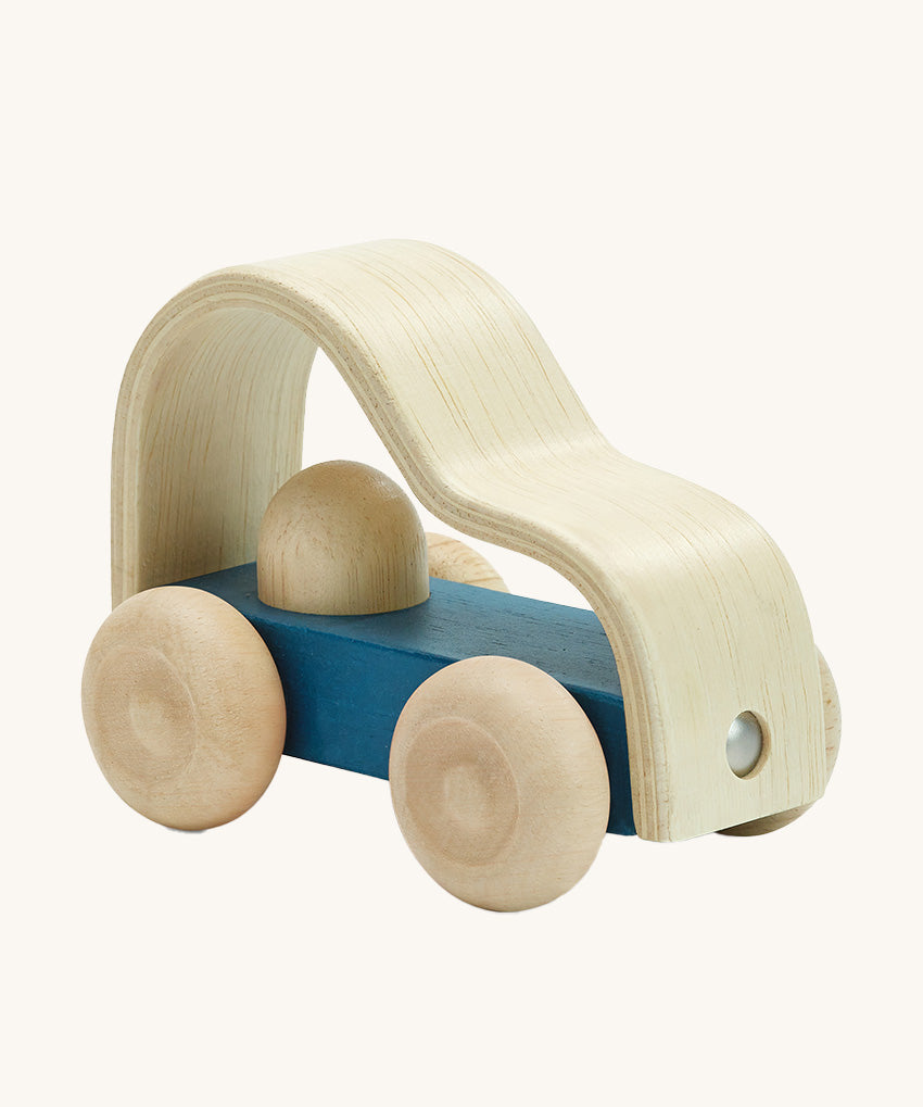 Plan toys childrens eco-friendly wooden vroom truck toy on a cream background