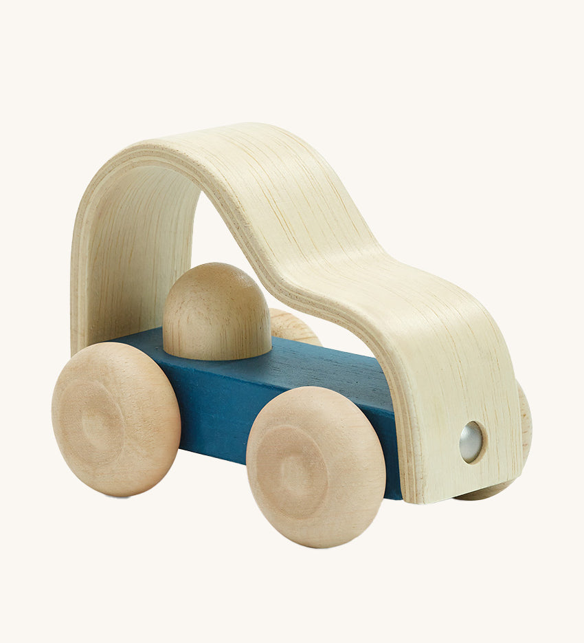 Plan toys childrens eco-friendly wooden vroom truck toy on a cream background