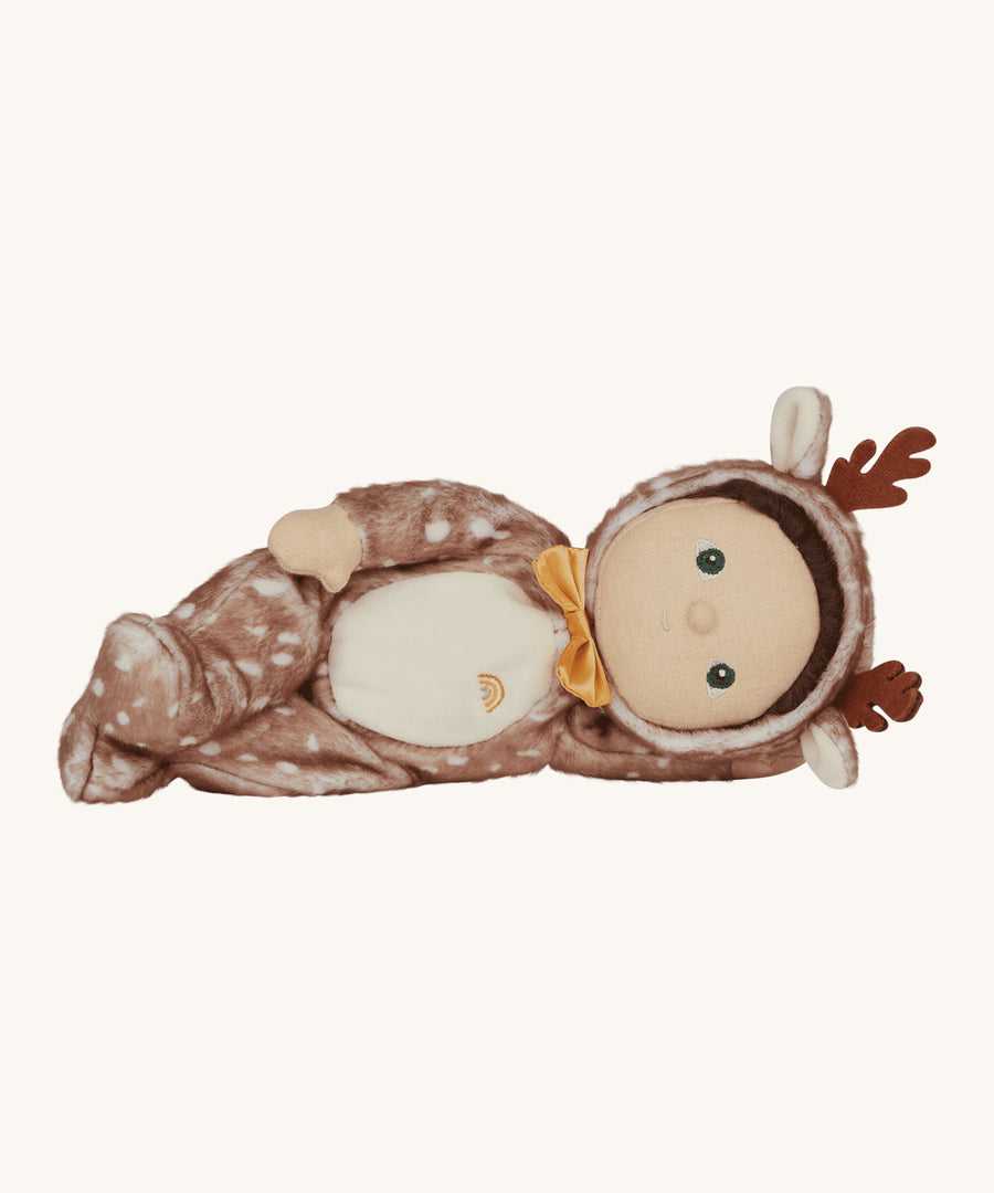 Riley Reindeer is lying on its side, looking comfy and cosy in its reindeer onsie. This image is on a cream background