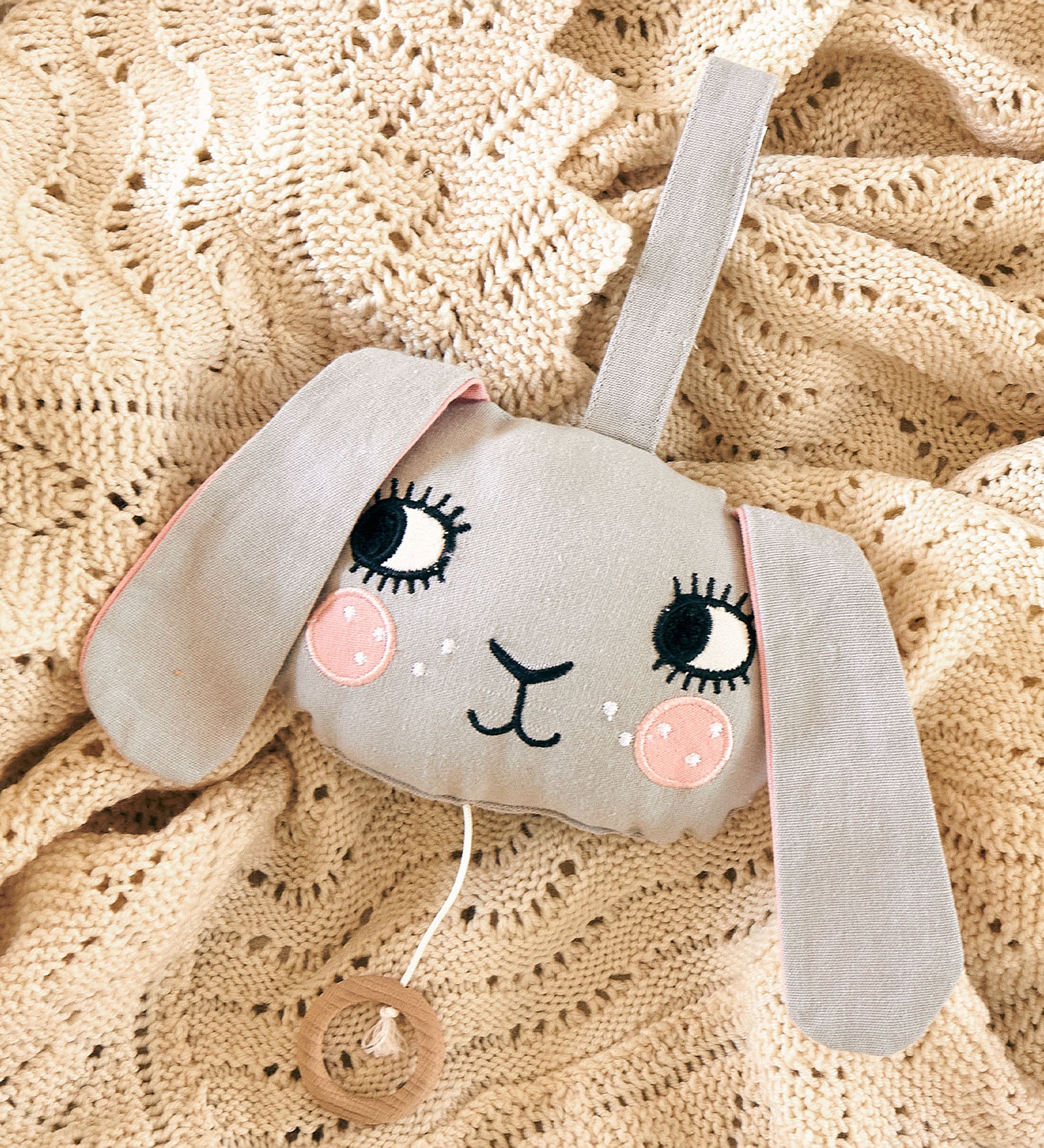 The Roommate Musical Baby Mobile - Bunny on a beige baby blanket