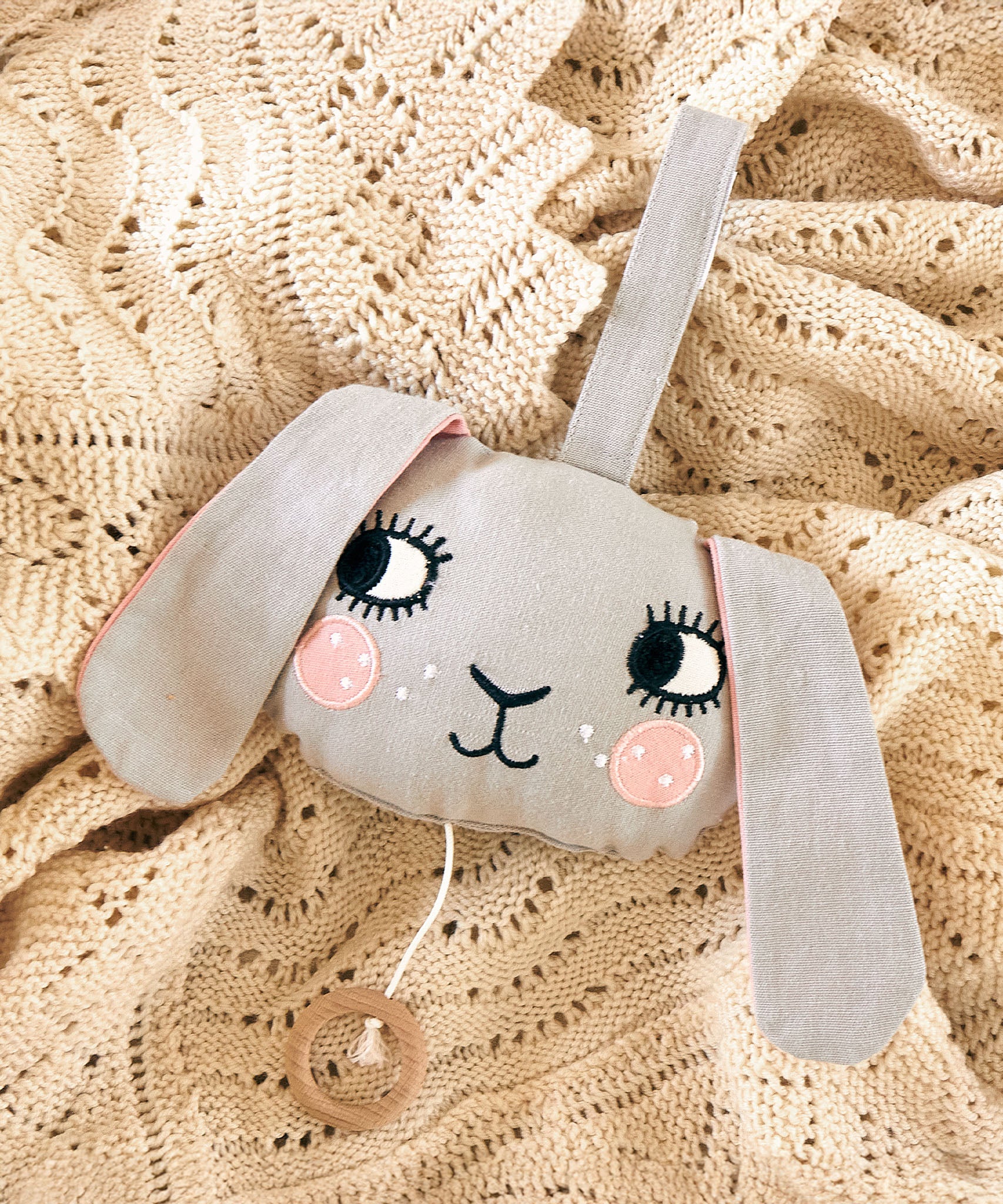 The Roommate Musical Baby Mobile - Bunny on a beige baby blanket