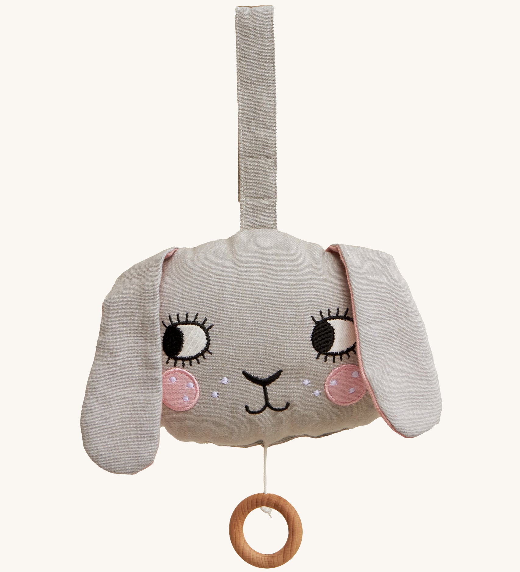 Roommate Musical Baby Mobile - Bunny, in grey. Shaped as a bunny face with pink cheeks, two floppy ears and a pull cord with a wooden hoop, on a cream background