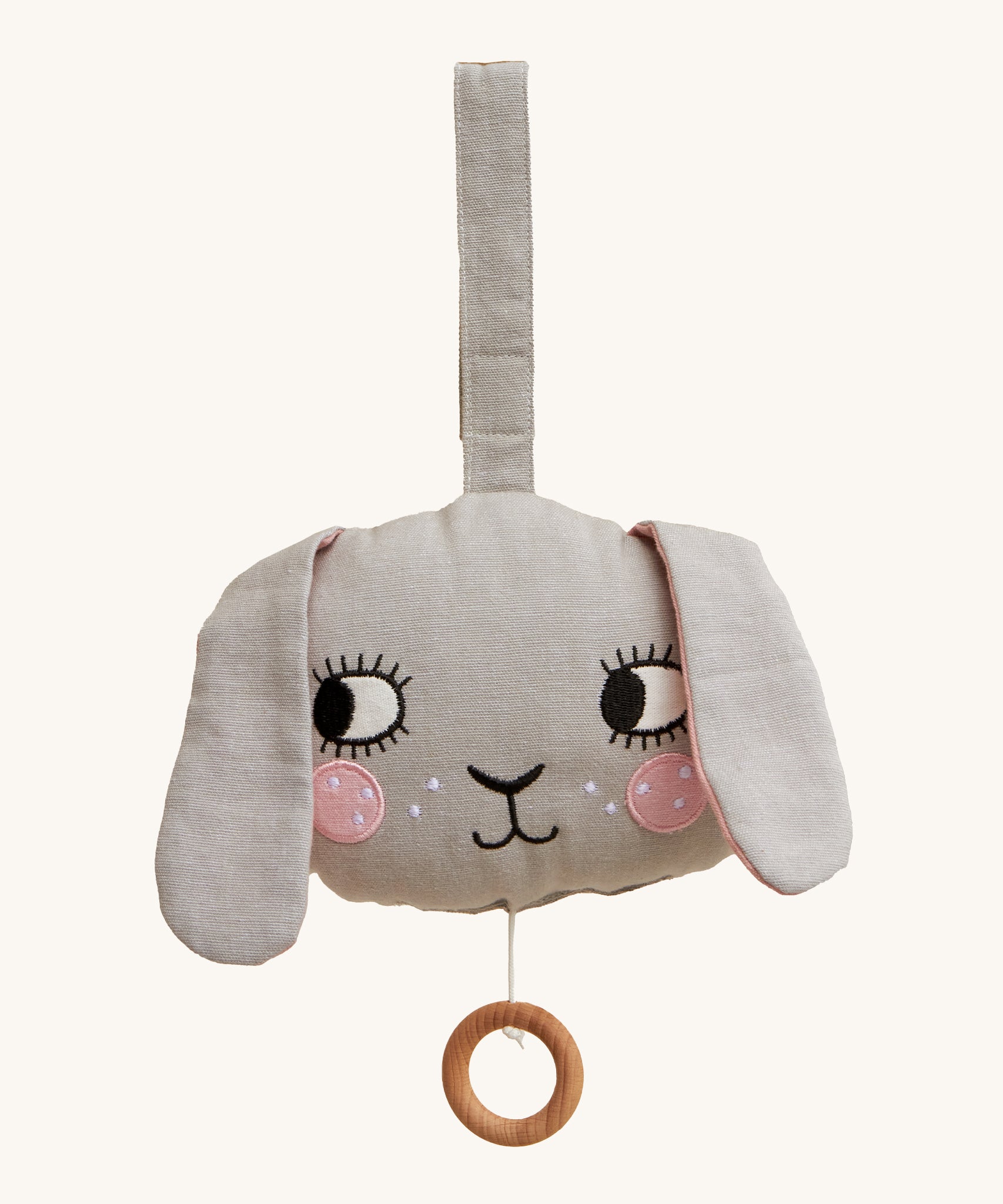 Roommate Musical Baby Mobile - Bunny, in grey. Shaped as a bunny face with pink cheeks, two floppy ears and a pull cord with a wooden hoop, on a cream background