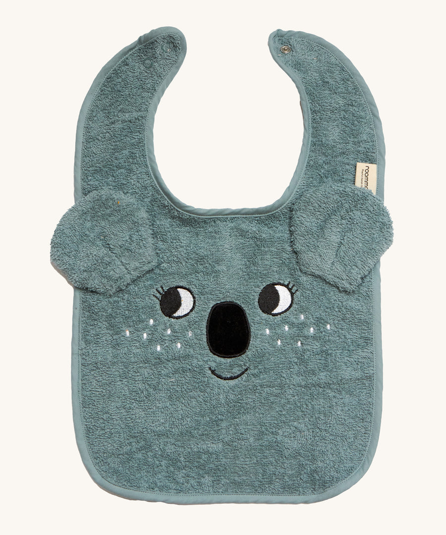 Roommate Organic Cotton Baby Bib - Koala is a soft flannel baby bib with a koala face, interactive koala ears, and metal popper fasteners to close the bib at the back of the neck. The image is on a cream background