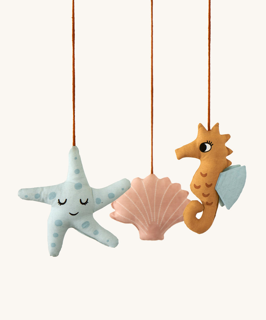 A closer look at the details on the Roommate Sealife Hanging Mobile. The blue starfish has sleepy eyes and dark blue spots. The Pink shell has sleepy eyes and white shell lines, and the sea horse is wide awake with light blue fins on its back