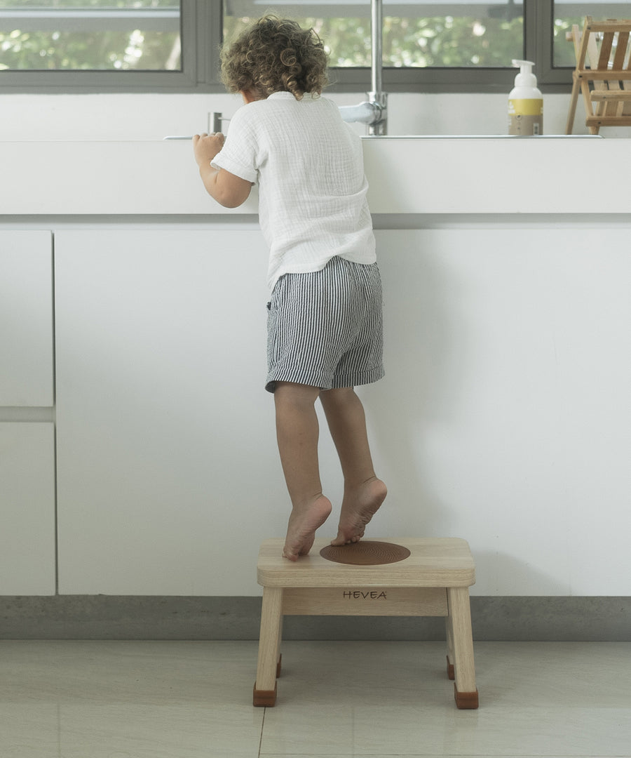 Child in stood on a Hevea Rubberwood Step Stool reaching into a sink. 