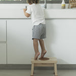 Child in stood on a Hevea Rubberwood Step Stool reaching into a sink. 